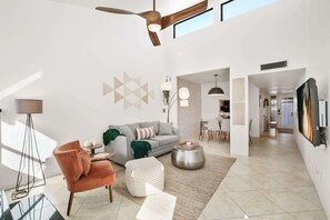 A modern living room with a sofa, ottoman, floor lamp, and ceiling fan. - Pool & Pet Friendly-Walk to Udall Park (Tucson)