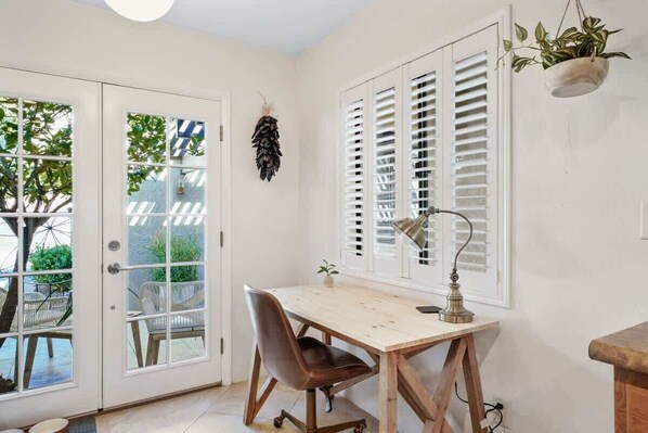 A room with a wooden desk, a chair, a desk lamp, and a window with shutters. - Pool & Pet Friendly-Walk to Udall Park (Tucson)