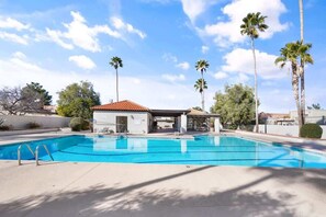 A swimming pool with a covered area, palm trees, and a clear sky. - Pool & Pet Friendly-Walk to Udall Park (Tucson)