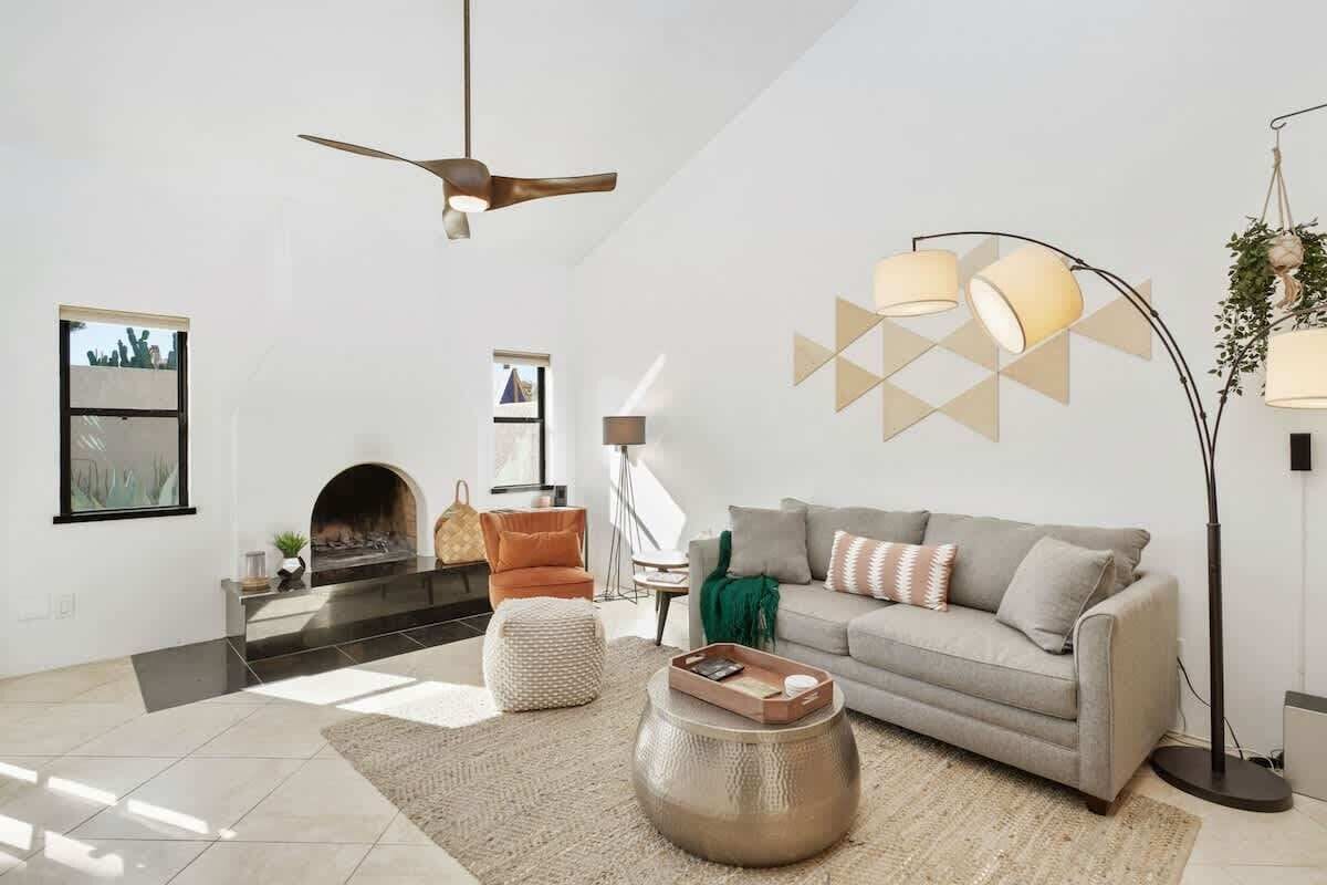 A modern living room with a fireplace, a sofa, a coffee table, and a floor lamp.