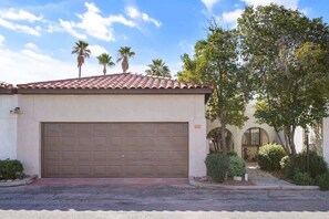 A residential building with a garage, palm trees, and a clear sky. - Pool & Pet Friendly-Walk to Udall Park (Tucson)