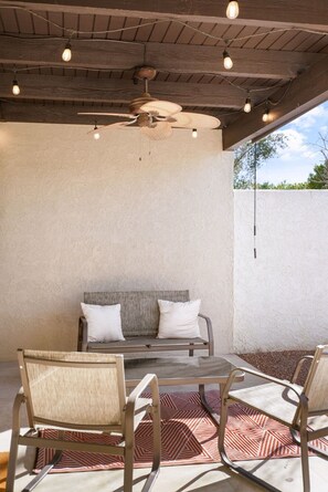 An outdoor patio with a ceiling fan, a cushioned bench, and metal chairs. - Pool & Pet Friendly-Walk to Udall Park (Tucson)