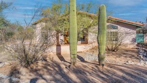 A desert landscape with two tall cacti and a building with a red roof. - Catalina Mountain Views with Pool (Tucson)