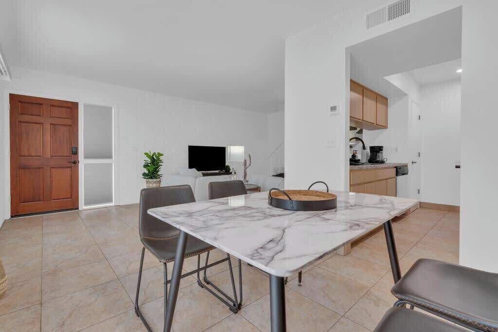 A modern kitchen with white cabinets, a black countertop, and a built-in oven.