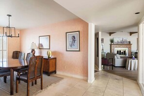 A spacious living room with a dining area, a fireplace, and a cityscape painting on the wall. - Sonoran Paradise with Pool (Tucson)