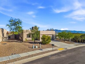 A modern building with a gravel driveway, a small tree, and a clear sky. - Quiet Desert Haven- 5 mins to Starr Pass (Tucson)
