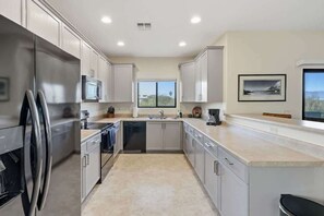 A modern kitchen with stainless steel appliances, a dishwasher, and a window providing natural light. - Quiet Desert Haven- 5 mins to Starr Pass (Tucson)