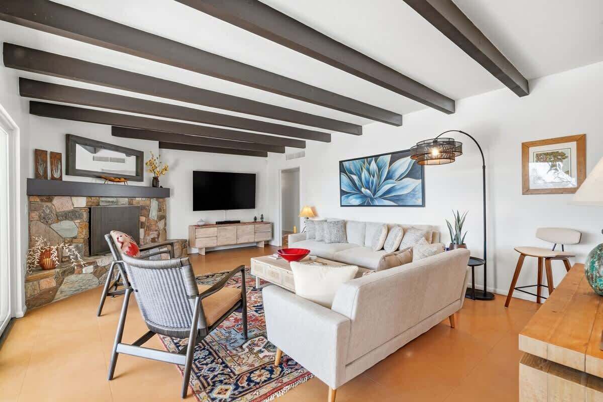 Un salon moderne avec une cheminée, un canapé, une table basse et un téléviseur.