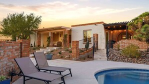A poolside area with lounge chairs, a brick house, and a pool. - Catalina Foothills Luxe Retreat with Heated Pool! (Tucson)