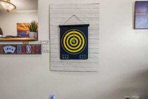 Eine Dartscheibe an einer Wand, unterhalb befindet sich ein Schild mit der Aufschrift 'FREE ROOM'.