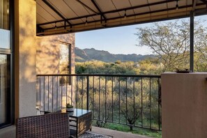 A balcony with a table and chairs, a view of trees and mountains, and a pergola structure. - Sanctuary Escape with Heated Pools & Views (Tucson)