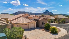 A residential area with houses featuring tiled roofs, a clear sky, and mountains in the background. - Desert Solace Retreat w/Pool/Spa (Tucson)