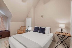 A bedroom with a bed, a chair, a small table, and a lamp. - Charming Barrio Adobe (Tucson)