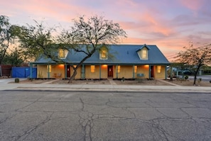 A two-story house with a blue roof, multiple windows, and a front porch. - Charming Barrio Adobe (Tucson)