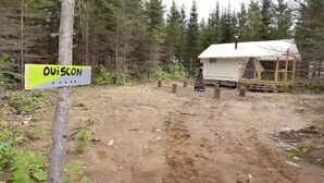 Ein Campingplatz mit Zelt und einem Schild mit der Aufschrift 'QUIISCON'.