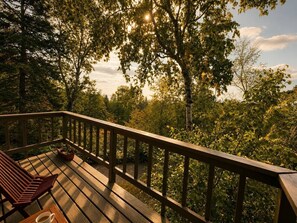 Une terrasse en bois avec un banc et un pot de fleurs.