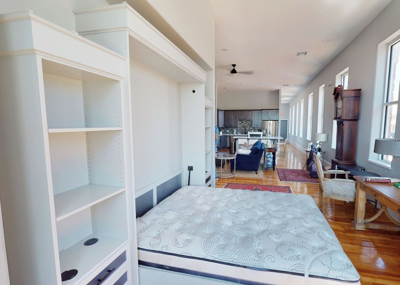 Un amplio salón con sofá, mesa de centro y estantería.