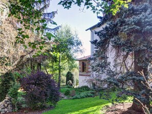 A house with a garden, a stone wall, and a tree. - Charming apartment with garden - 2 guests (Andrézieux-Bouthéon)