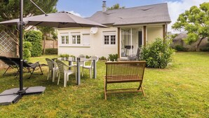 Una casa con patio, mobiliario exterior y una antena parabólica.