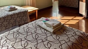 A room with two beds, a television, and a window. - Isla Bella (Ushuaia)