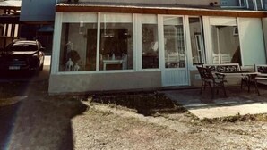 A two-story building with a flat roof, large windows, and a covered patio area. - Isla Bella (Ushuaia)