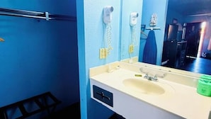 A bathroom with a sink, mirror, towel rack, and a towel hanging on the wall.