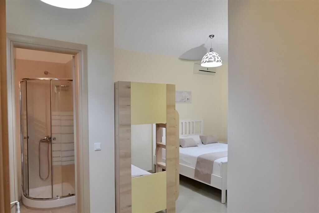Een slaapkamer met een bed, nachtkastje en douche.