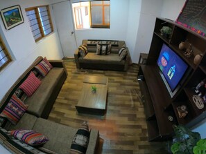 A living room with a sofa, a coffee table, and a television. - EKEKOS CUSCO (Cusco)