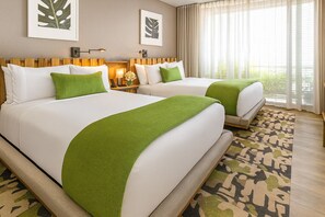 Ein Hotelzimmer mit zwei Betten, einem gemusterten Teppich und Bildern an den Wänden.