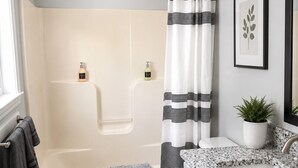A modern bathroom with a shower, toilet, and sink.