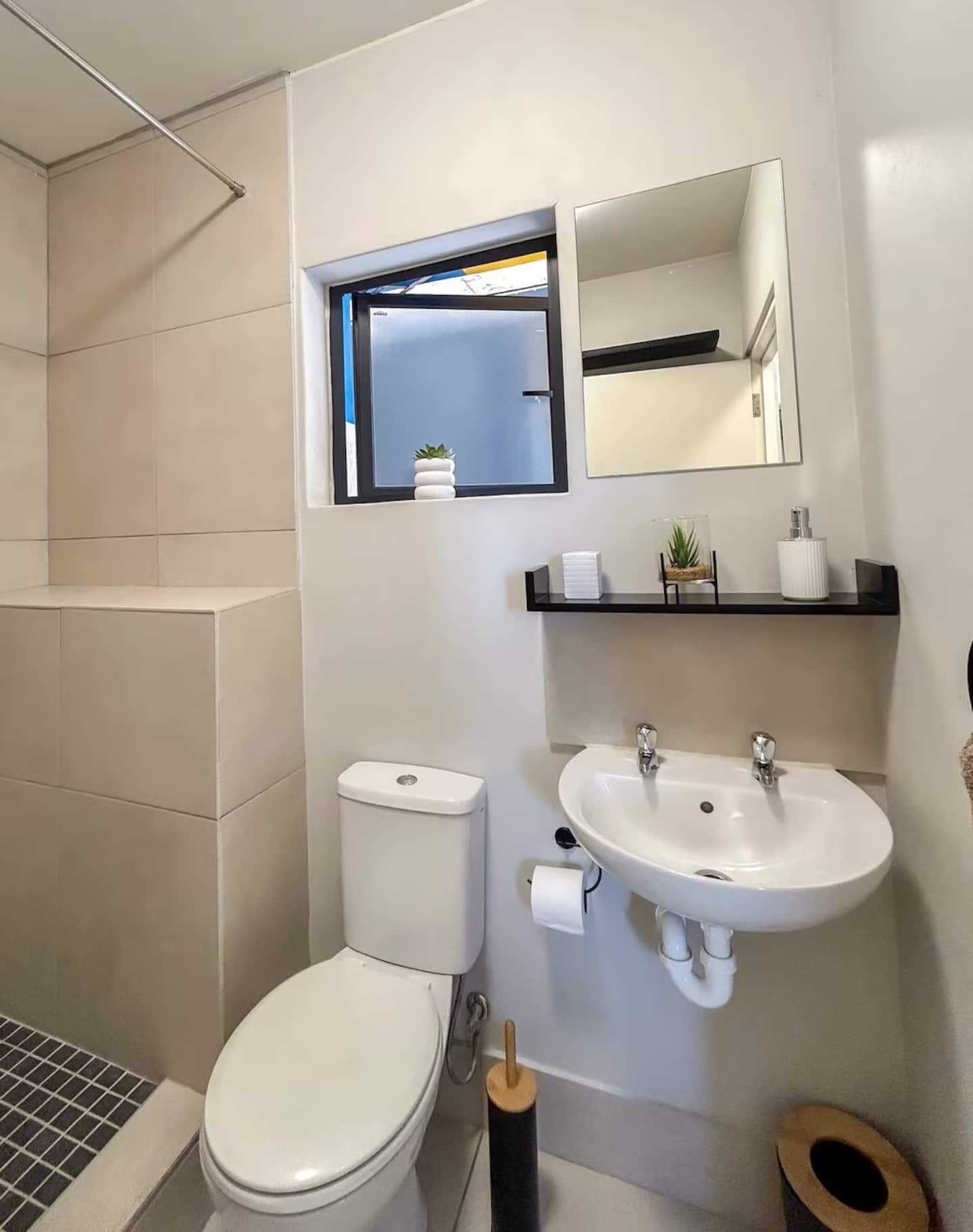 Une salle de bain moderne équipée de toilettes, d’un lavabo et d’une douche.