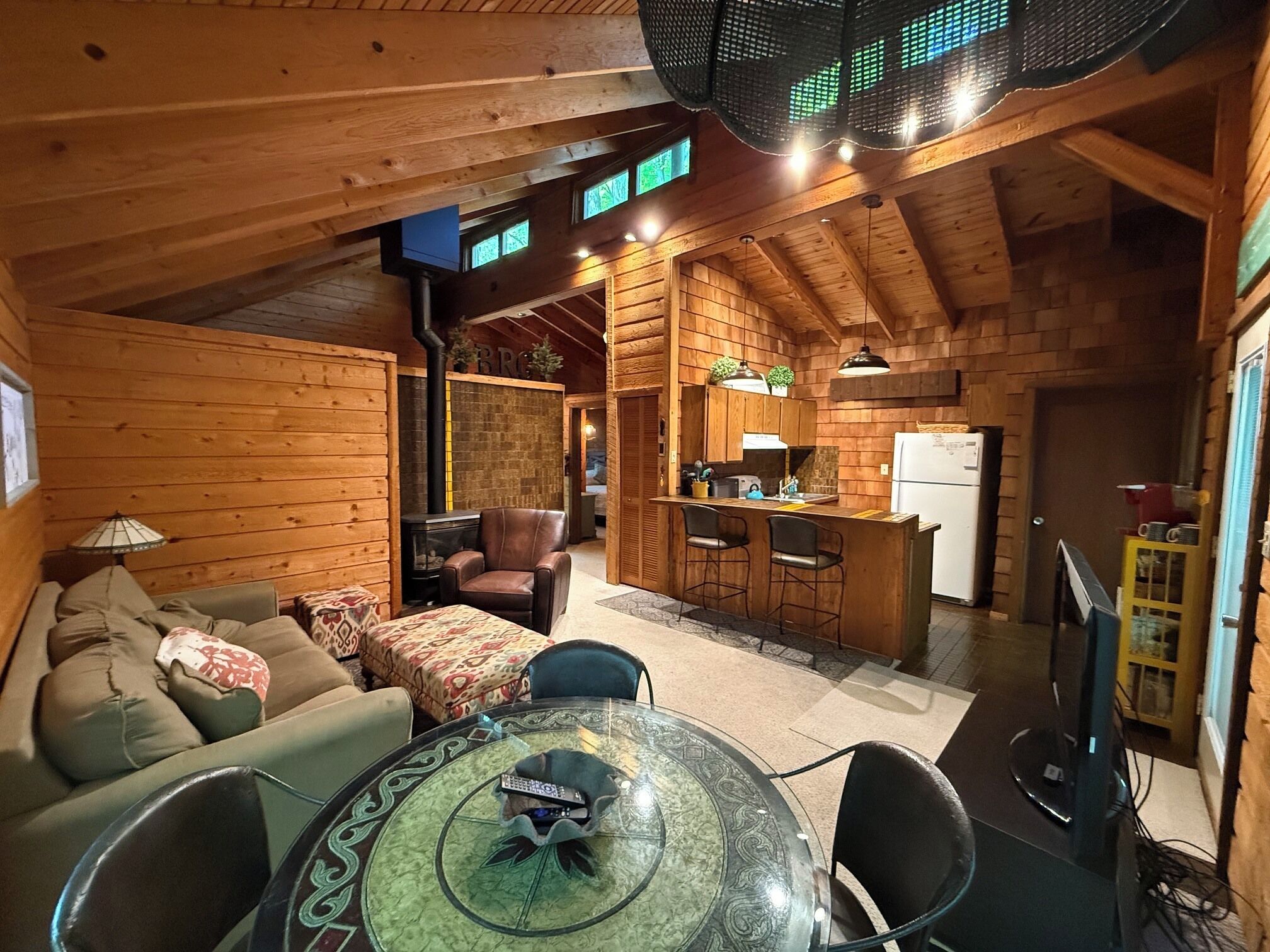 Interior acogedor de una cabaña con sala de estar, una mesa de comedor y una cocina.
