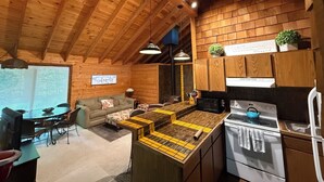 A cozy cabin-style interior with a kitchen, dining area, and a living room.