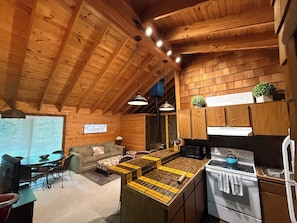 A cozy cabin-style interior with a kitchen, dining area, and a living room.