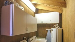 A compact laundry room with a washing machine, dryer, and a small sink.