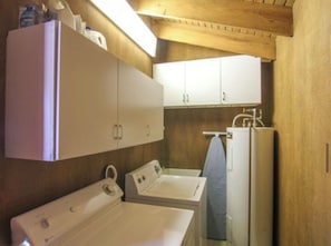 A compact laundry room with a washing machine, dryer, and a small sink.
