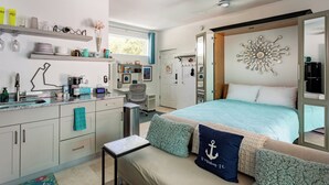 Een moderne slaapkamer met een bed, nachtkastje en een bureau met stoel.