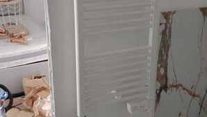 A room with a white radiator, a damaged wall, and a visible floor. - Apartment in the village of Tomino, 10 minutes from the sea and Macingaggio. (Tomino)
