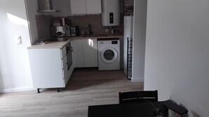 A compact kitchen with a washing machine, a microwave, and a refrigerator. - Apartment in the village of Tomino, 10 minutes from the sea and Macingaggio. (Tomino)