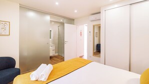 Una habitación de hotel con cama, sofá, baño y armario.