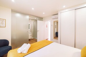 A hotel room with a bed, a sofa, a bathroom, and a wardrobe. - Casa Amarela do Redondo - Seixal - Madeira Island (Seixal)