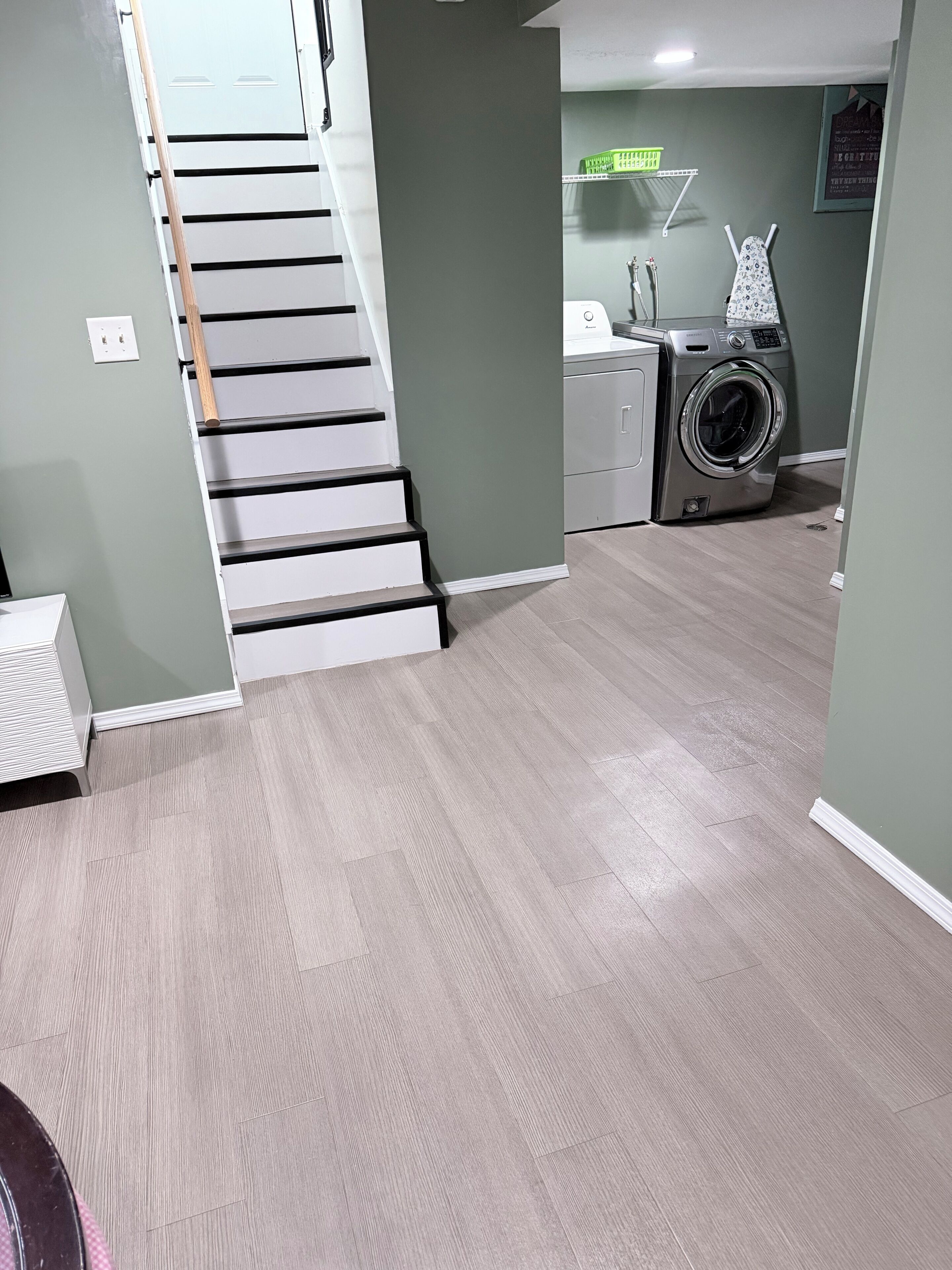 A laundry area with a washing machine, a dryer, and a ironing board.