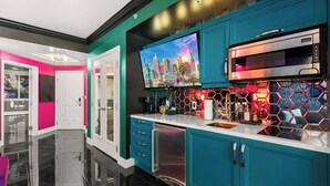 Een moderne keuken met turquoise kastjes, een roestvrijstalen oven en een stadslandschap schilderij boven de aanrecht.