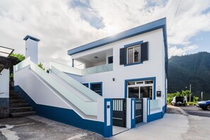 Ein modernes, zweigeschossiges Gebäude mit Treppe, Balkon und Garage.