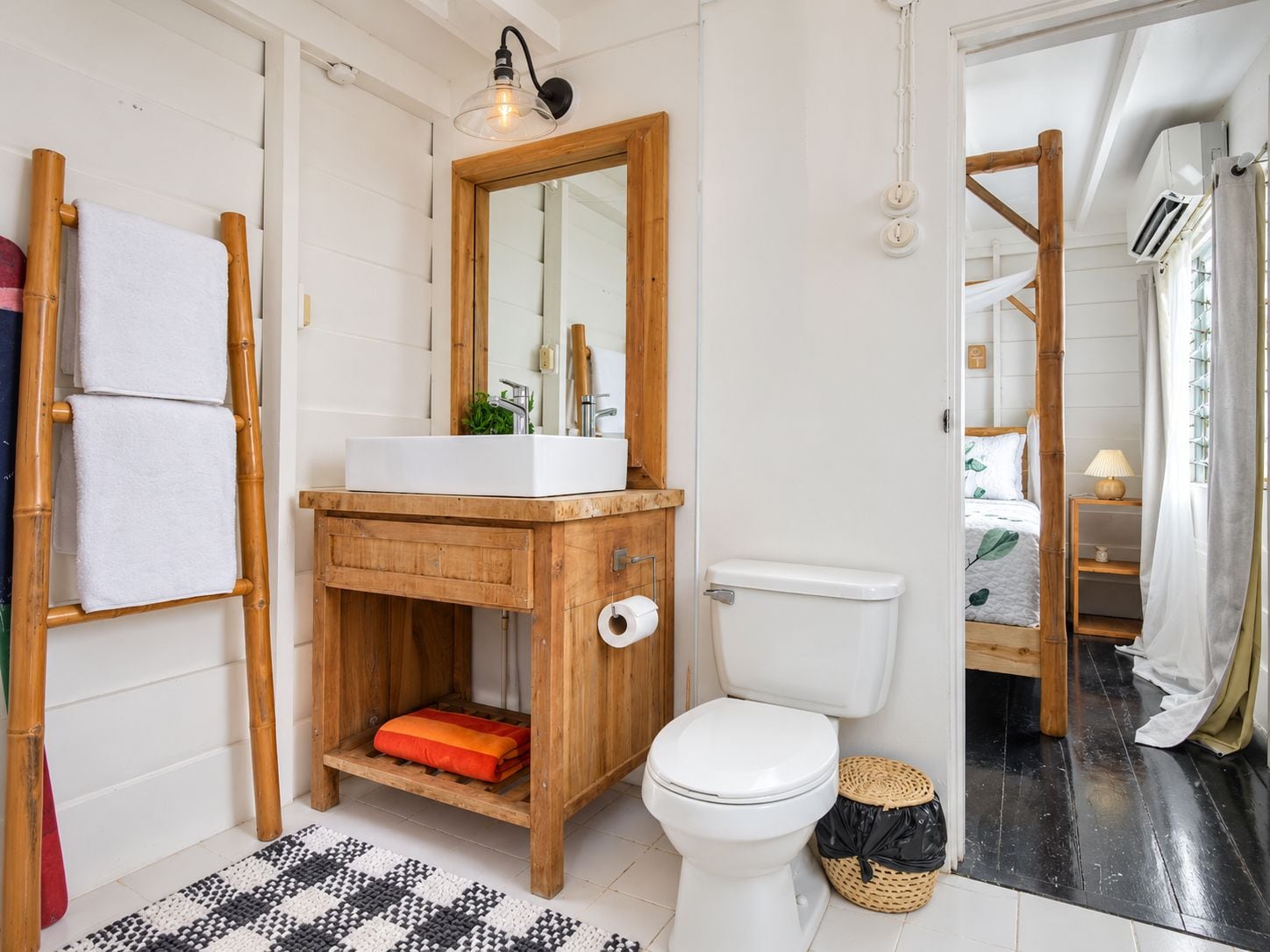 Une salle de bain avec un meuble-lavabo en bois, des toilettes et un espace douche.