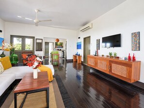 Amplia sala de estar con sofá, mesa de centro y televisor.