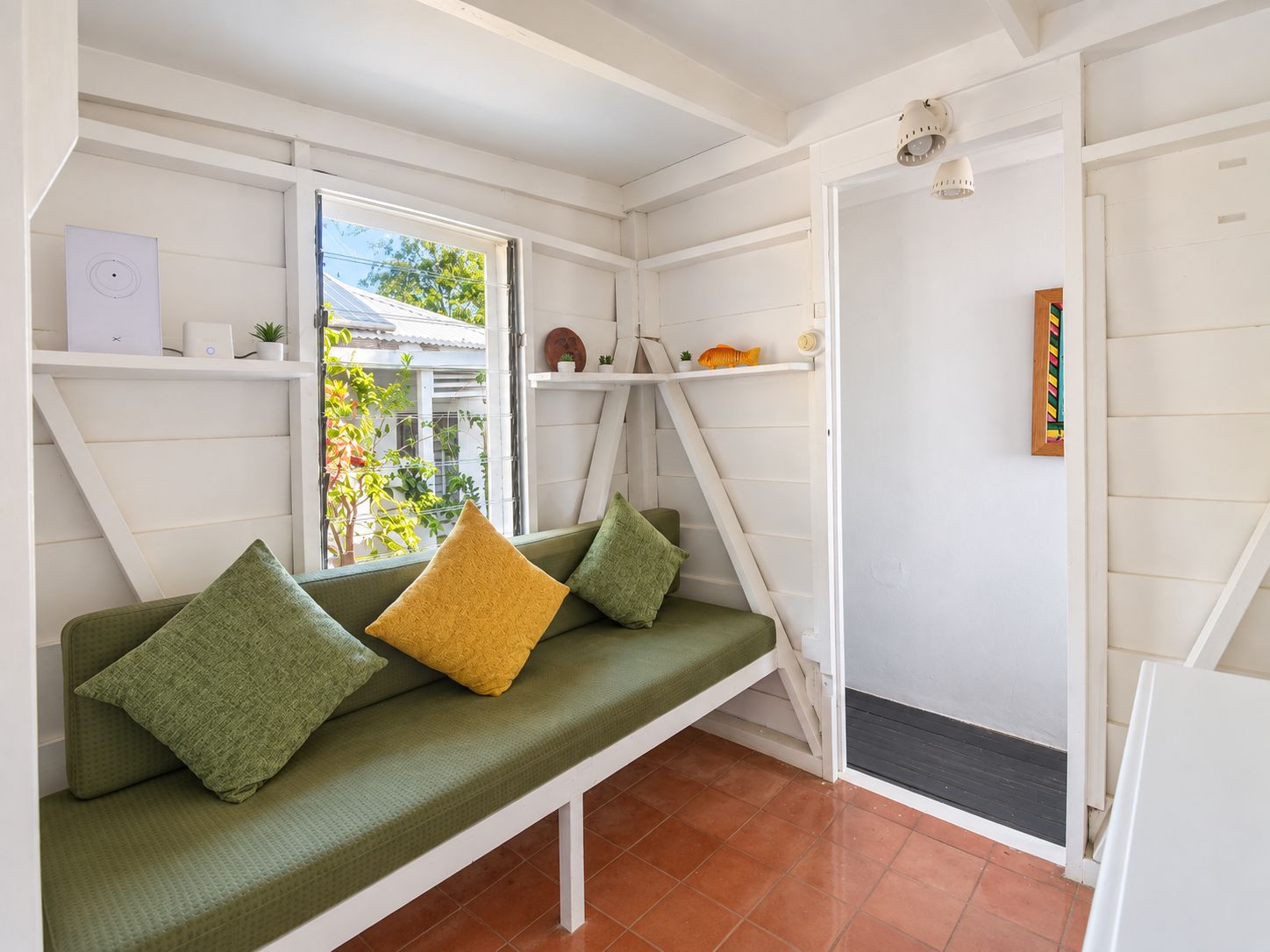 A room with a bench, a door, and a window.
