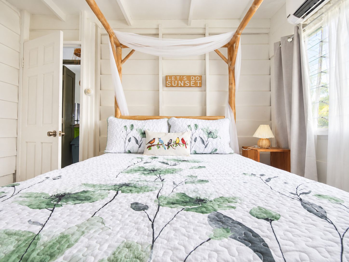 Quarto com cama de dossel, um aviso na parede e vista para o exterior.
