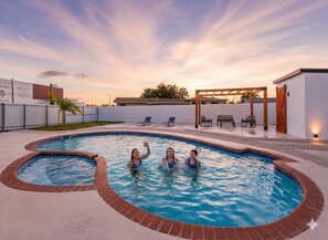 A swimming pool with three people in the water, surrounded by a brick deck and a pergola. - 4 Bedrooms - Private Pool Games Room (Miami Gardens)