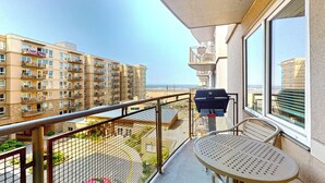 Un balcone con vista su una spiaggia e grattacieli.